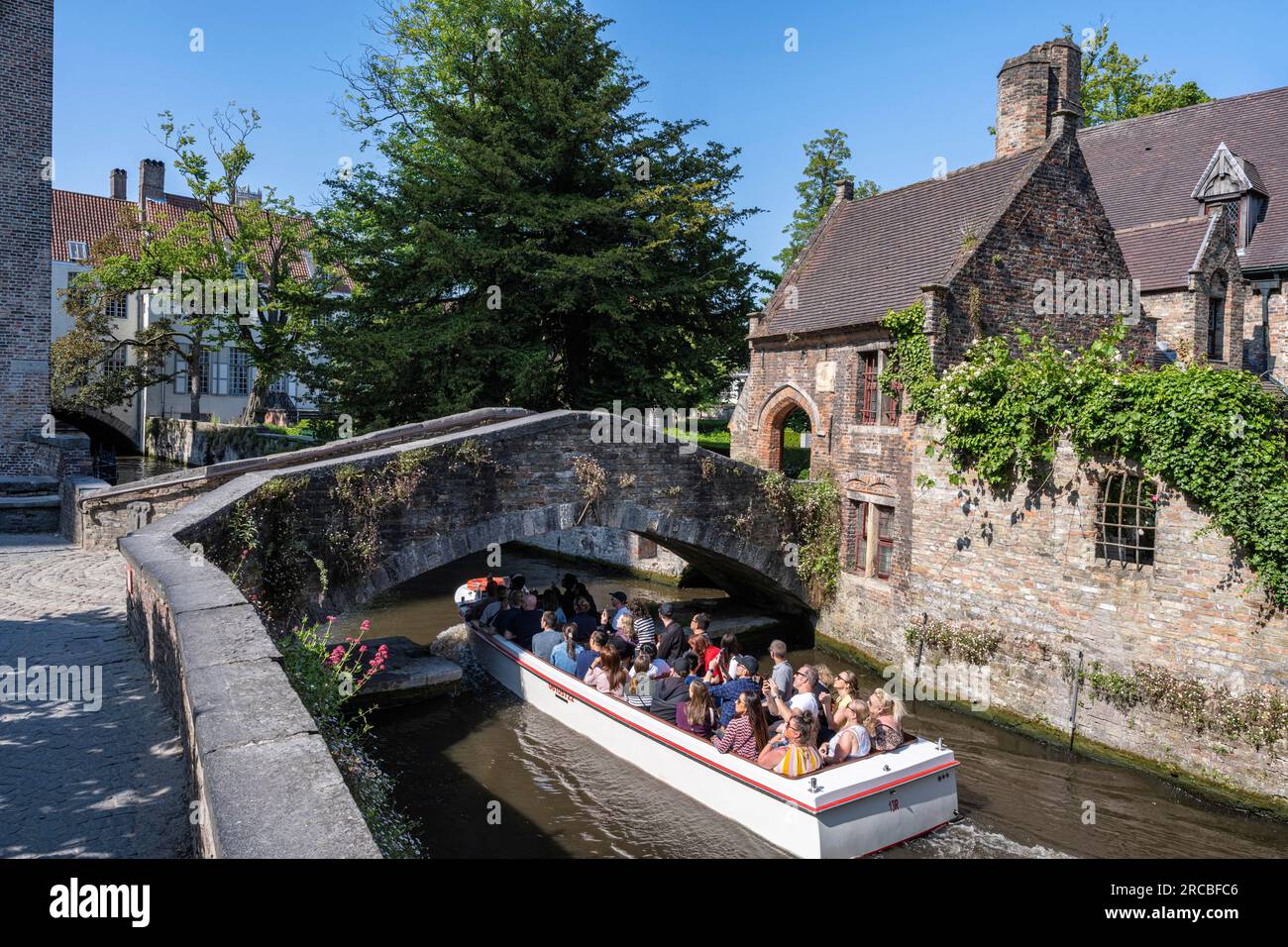 Gita sul canale sotto il ponte di Boniface e tra edifici medievali, Bruges, Fiandre, Belgio Foto Stock