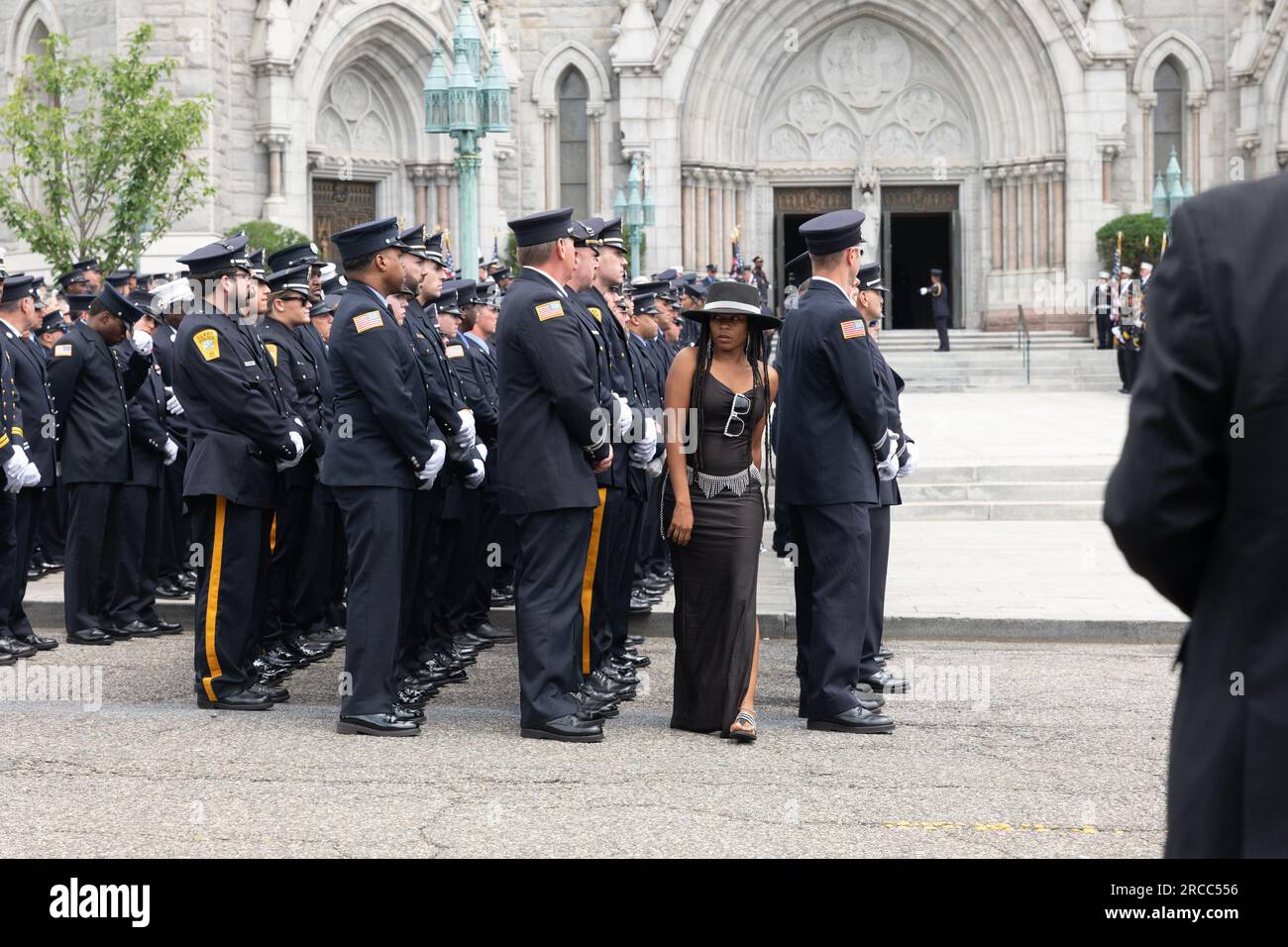 Newark, New Jersey, USA. 13 luglio 2023. Una donna cammina attraverso il resto della parata del vigile del fuoco dopo la processione funebre del caduto combattente del fuoco di Newark Augusto Acabou presso la Basilica Cattedrale dei Sacri cuori dopo il suo servizio funebre a Newark, NJ Acabou è stato uno dei due vigili del fuoco di Newark morti in servizio nel tentativo di estinguere il fuoco, che ha bruciato per quasi una settimana, sulla nave mercantile italiana a Port Newark a Newark, New Jersey (Credit Image: © Brian Branch Price/ZUMA Press Wire) SOLO PER USO EDITORIALE! Non per USO commerciale! Foto Stock