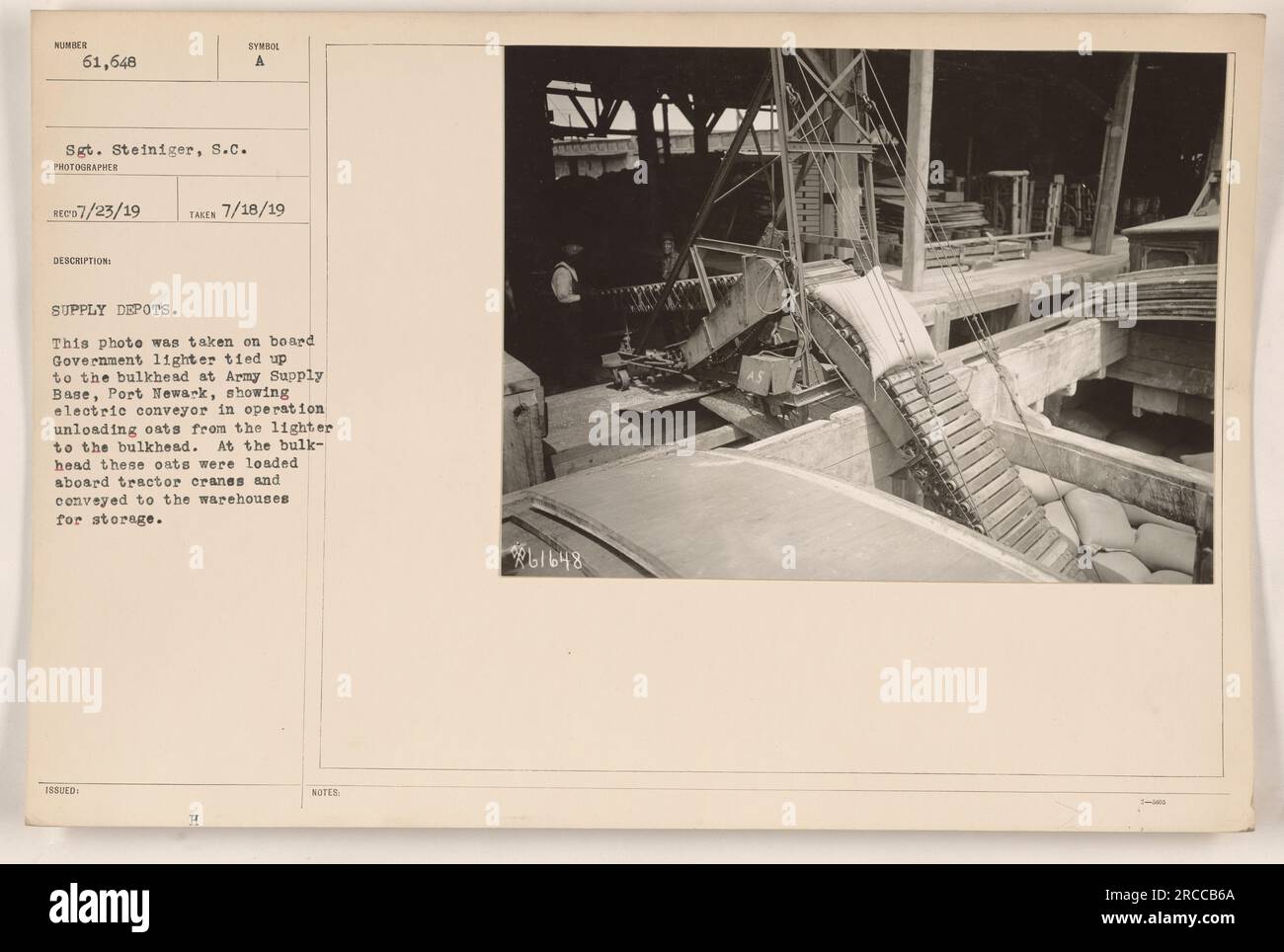 Questa fotografia mostra una scena alla base dell'esercito di Port Newark durante la prima guerra mondiale. Un accendisigari è legato alla paratia, con un trasportatore elettrico in funzione per lo scarico dell'avena. Questi avena vengono quindi caricati sulle gru dei trattori e trasportati ai magazzini per lo stoccaggio. Foto scattata dal sergente Steiniger. Foto Stock