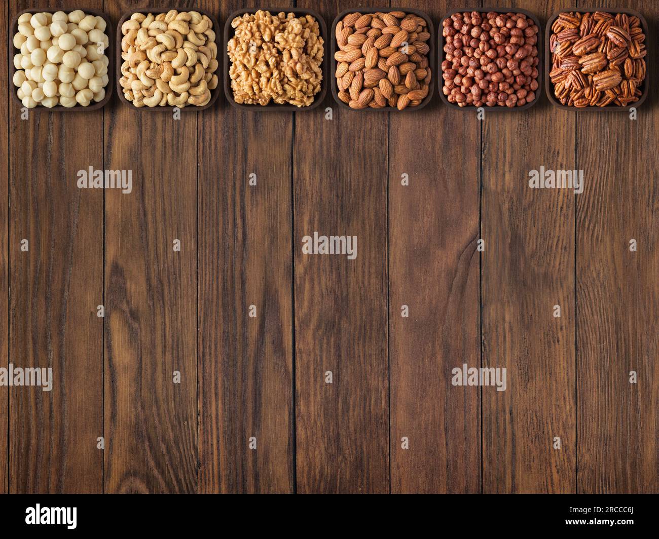 raccogliere noci e semi su fondo di legno del tavolo con spazio vuoto. Foto Stock