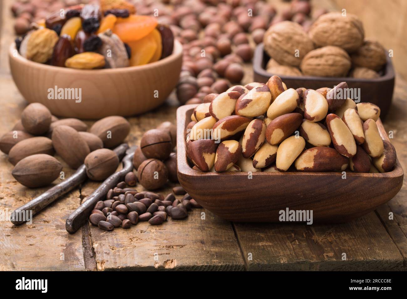 noci brasiliane sbucciate in un recipiente su un tavolo di legno. Alimenti utili per vegetariani e vegani. Foto Stock