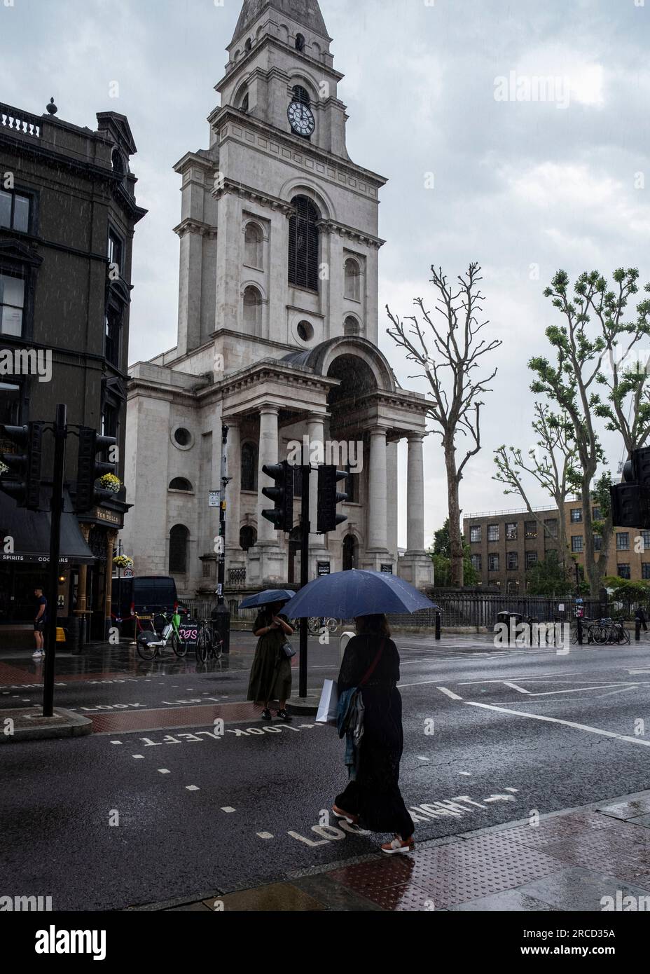 Un sabato piovoso con persone che tengono ombrelli a Spitalfields, nell'East End di Londra Foto Stock