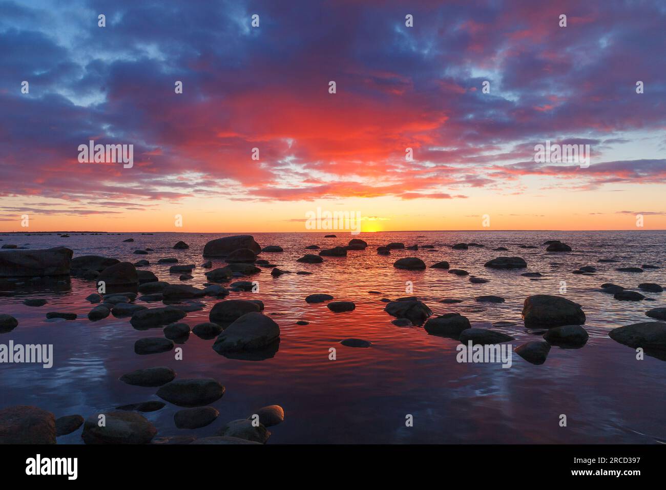Vista del tramonto in tarda rosso sulla costa rocciosa del mare, luce damatica, lunga esposizione Foto Stock