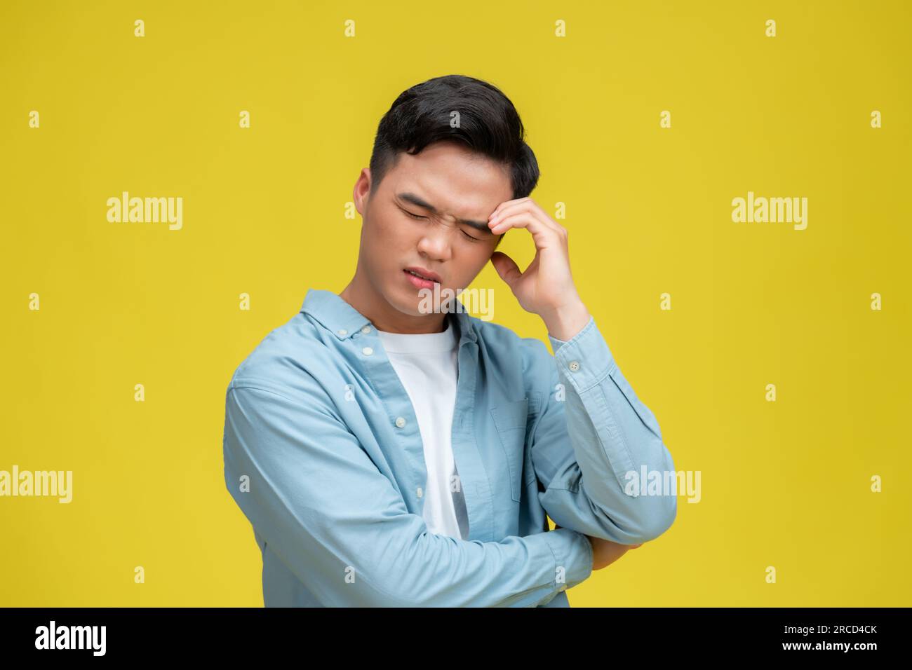 Immagine stock di uomo d'affari che copre gli occhi con le mani, su sfondo giallo Foto Stock