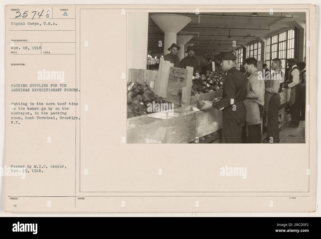 Soldati che preparano rifornimenti per le forze di spedizione americane. Si vedono mettere barattoli di manzo di mais in scatole su un nastro trasportatore nella sala di imballaggio di Bush Terminal, Brooklyn, New York. Questa immagine è stata approvata dal M.I.D. Censor il 19 novembre 1918. Foto Stock