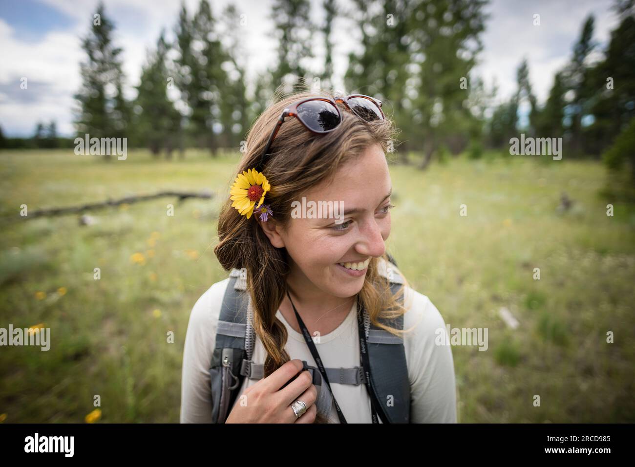 Primo piano di giovani donne sorridenti con fiori in capelli con campo dietro Foto Stock