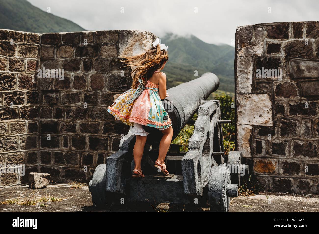 La giovane ragazza gioca nella vecchia fortezza in una fermata del porto delle navi da crociera di St Kitts Island Foto Stock