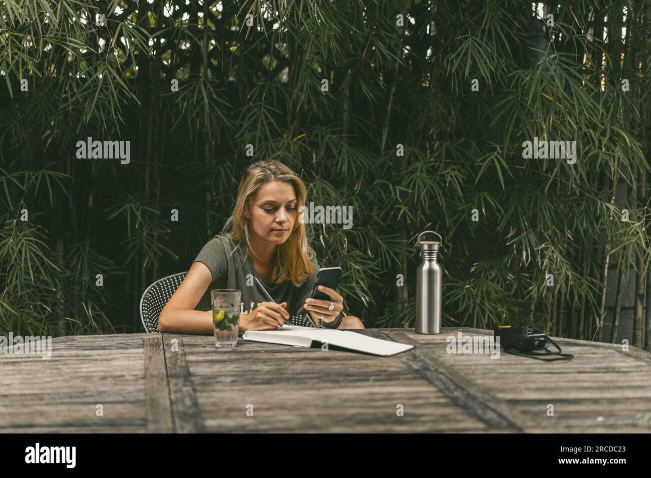 Una giovane donna scrive piani, fa un selfie, lavora come blogger. Foto Stock