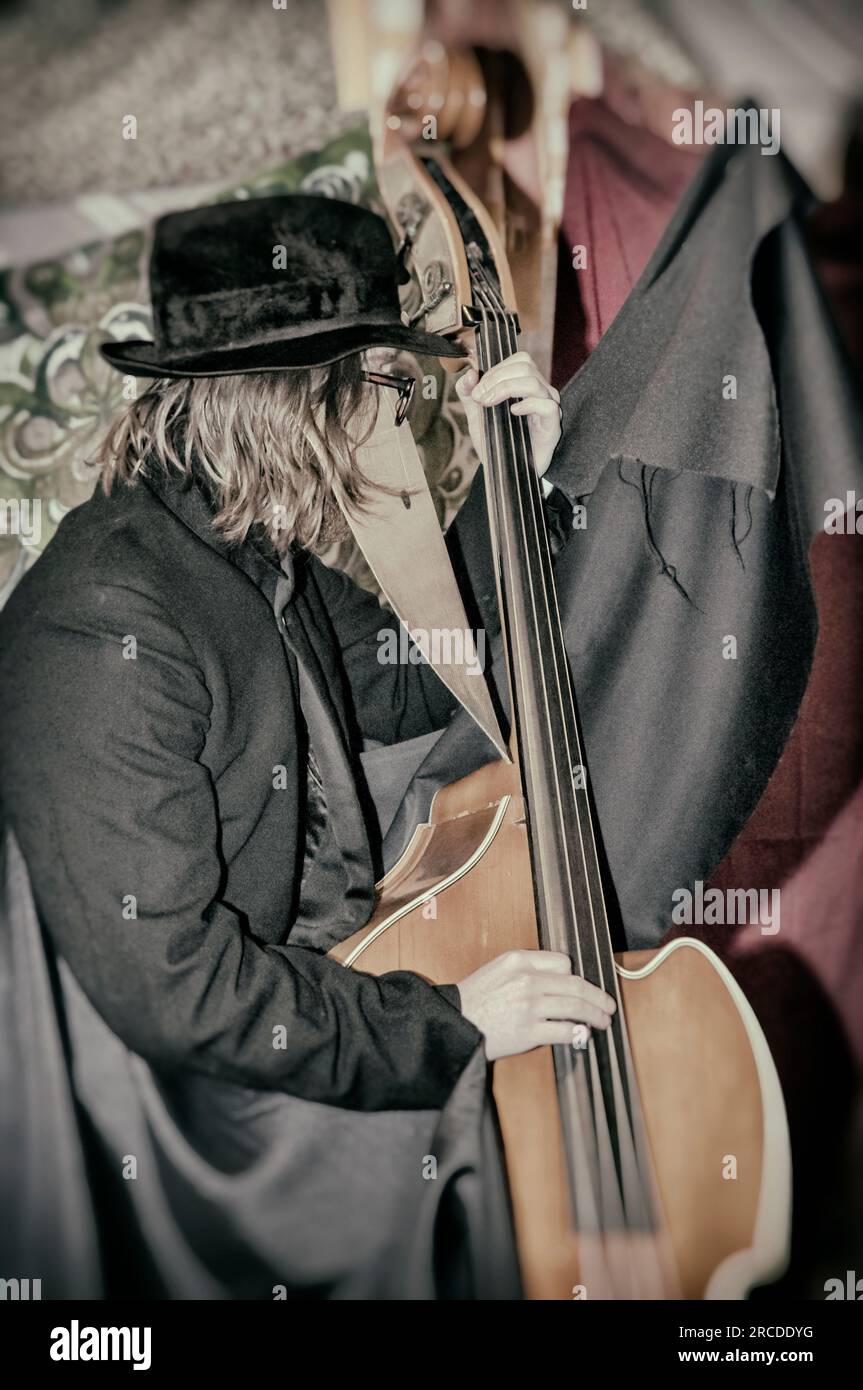 Grunge ruvida immagine artistica dell'uomo in maschera che suona il violoncello Foto Stock