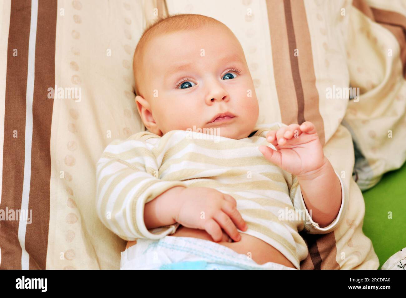 Ritratto ravvicinato dell'adorabile bambino di 4-5 mesi sdraiato su un cuscino Foto Stock