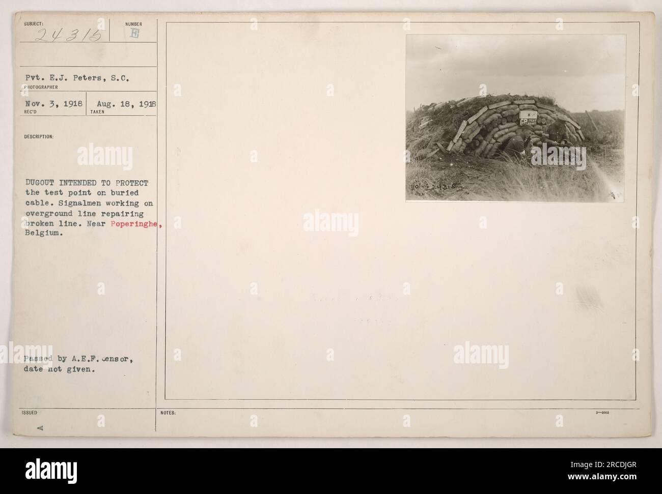 Signori che lavorano vicino a Poperinghe, in Belgio. Stanno riparando una linea tratteggiata su una linea telegrafica terrestre, mentre Pvt. E.J. Peters della S.C. scatta una foto. In primo piano è presente un dugout, destinato a proteggere il punto di prova su un cavo interrato. La foto è stata scattata il 18 agosto 1918. Foto Stock