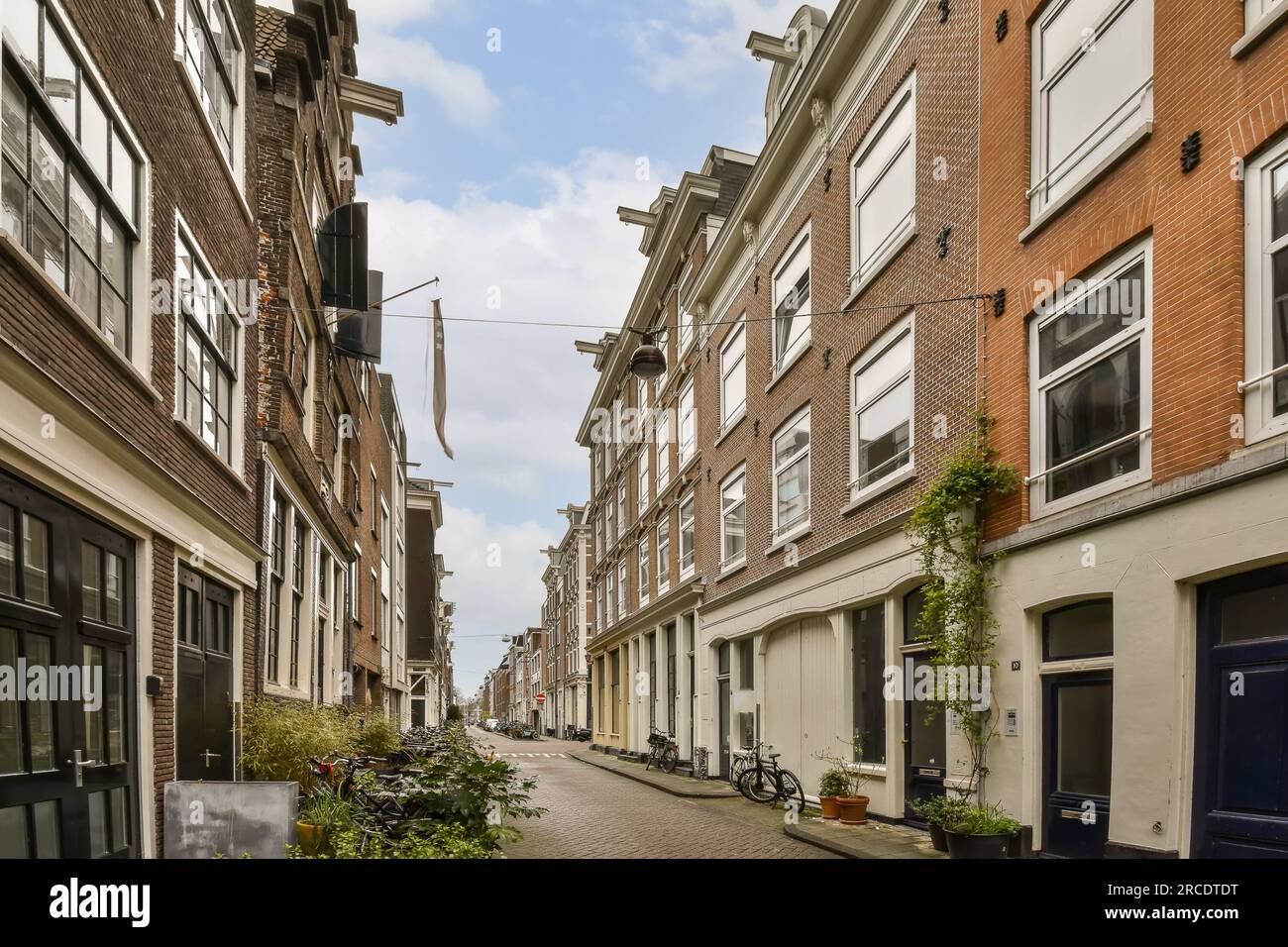 una strada stretta nei paesi bassi, con biciclette parcheggiate su entrambi i lati e edifici in mattoni che fiancheggiano i vicoli Foto Stock