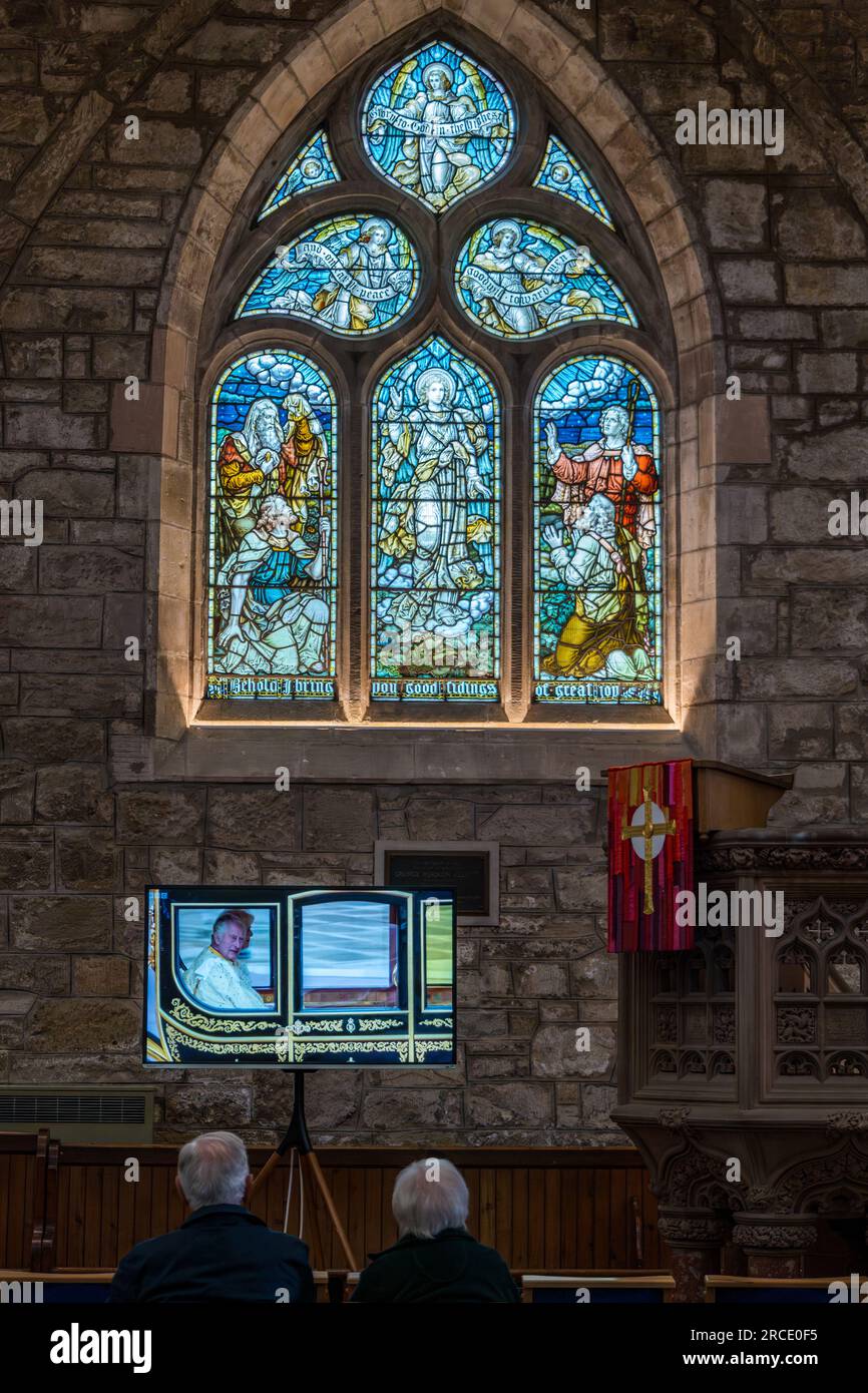 Persone che guardano l'incoronazione di re Carlo III sullo schermo TV, St Mary's Parish Church, Haddington, East Lothian, Scozia, Regno Unito Foto Stock