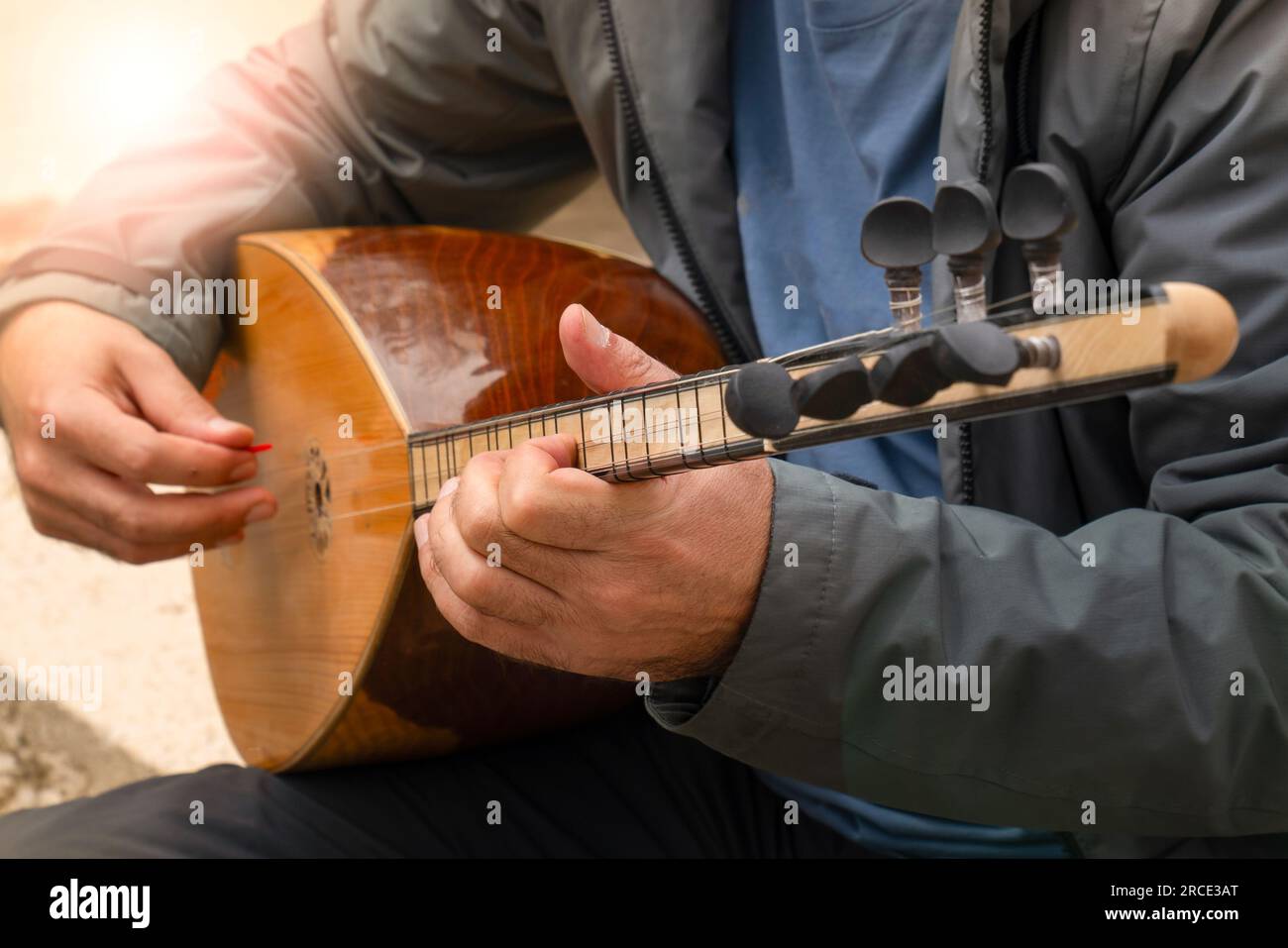 Uomo che suona lo strumento musicale turco baglama, che è lo strumento folk a corda più comunemente usato in Turchia Foto Stock