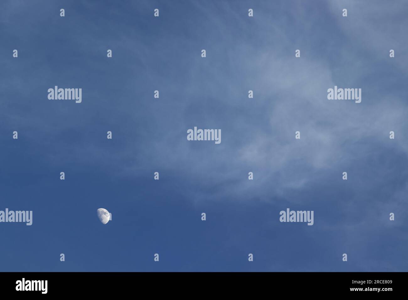 Luna gigantesca in un cielo blu con nuvole Foto Stock