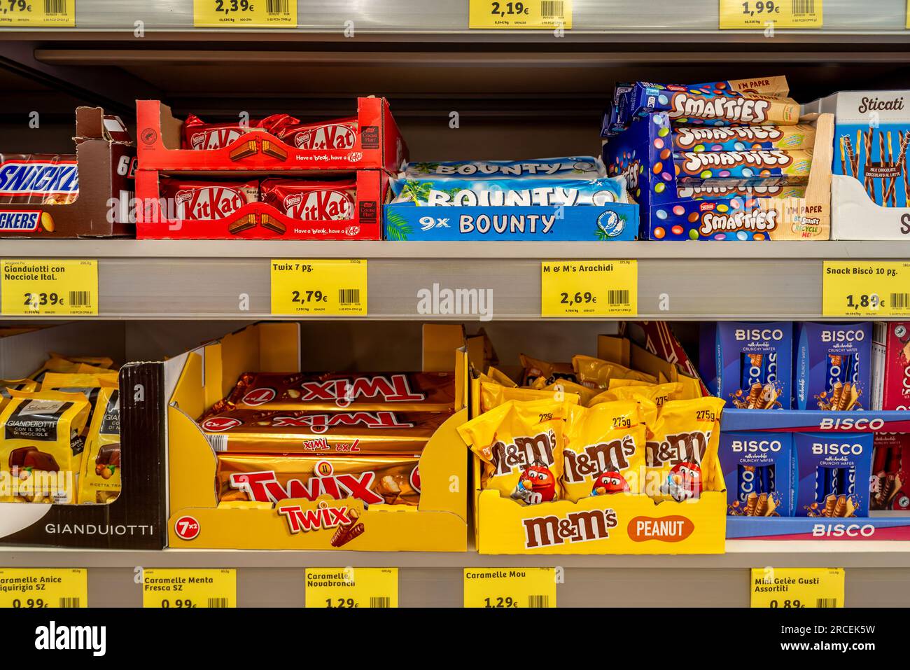 Italia - 13 luglio 2023: Pacchetti di caramelle KitKat e Bounty, Smarties e M e MS Peanut Candy e Bisco esposti in boxs di cartone marchiati in vendita Foto Stock