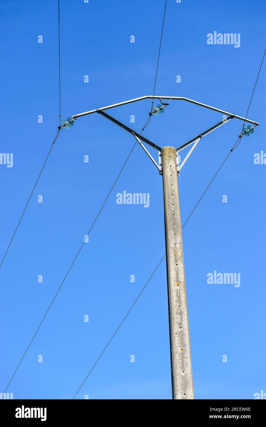 Poteaux electriques en beton. Transport d'energie sur Cables electriques passant de poteaux en poteaux dans un Village | i piloni elettrici transpo Foto Stock