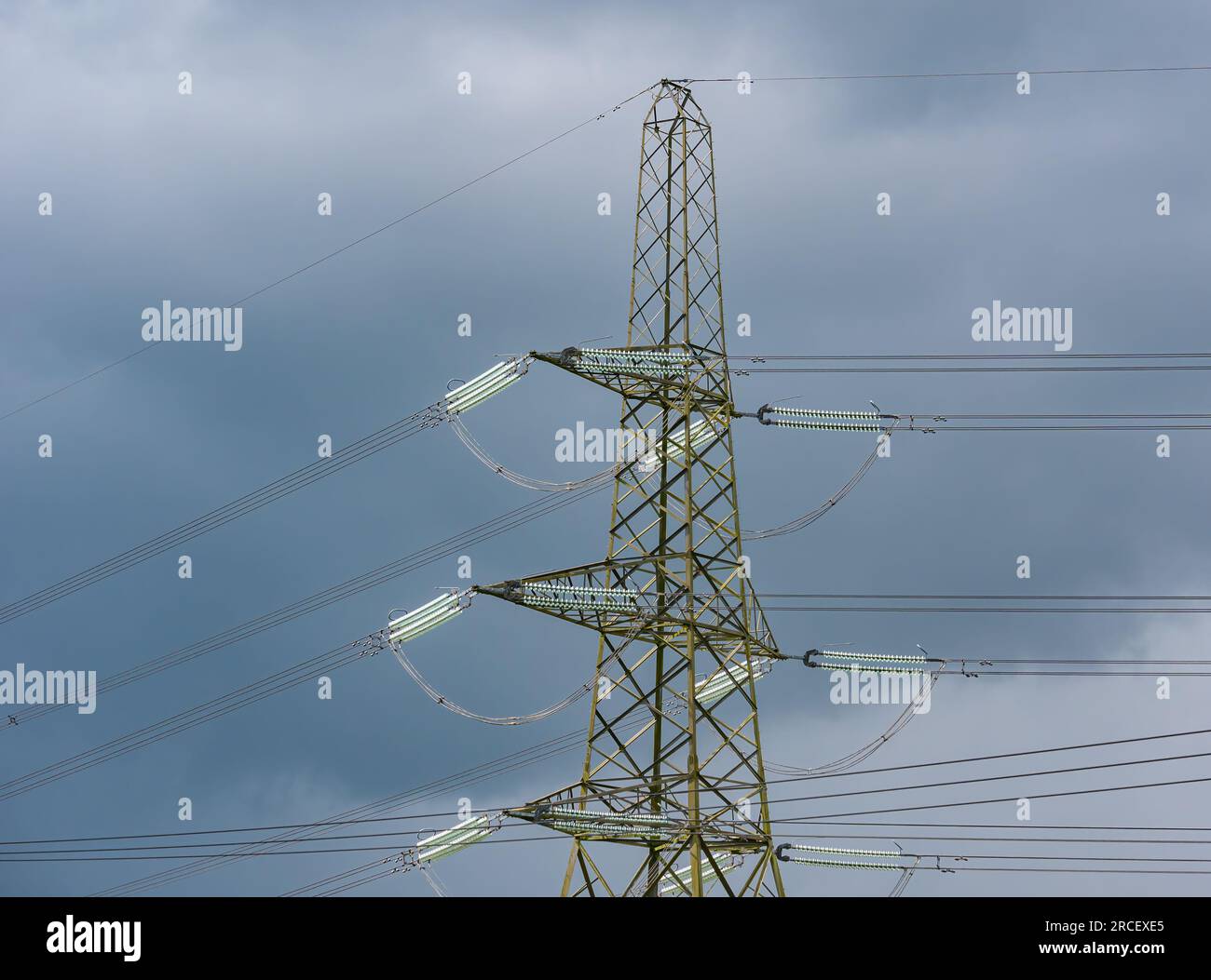 Traliccio elettrico alto che scintilla al sole con cielo tempestoso, Scozia, Regno Unito Foto Stock