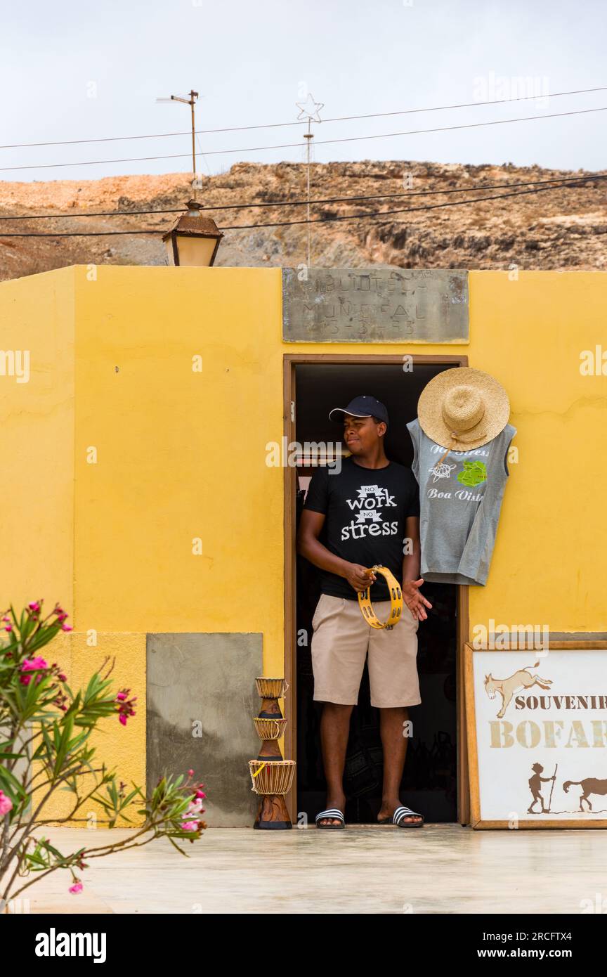 Young African Man che interpreta il Tambourine all'esterno di un negozio di souvenir, Boa Vista, Capo Verde, Africa Foto Stock