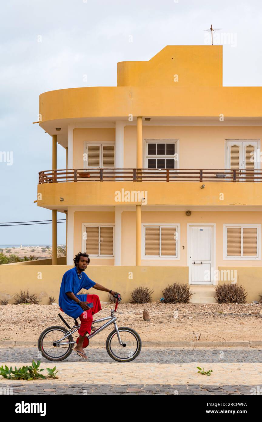 An African Man Cycling Down the Road, Boa Vista, Capo Verde, Africa Foto Stock