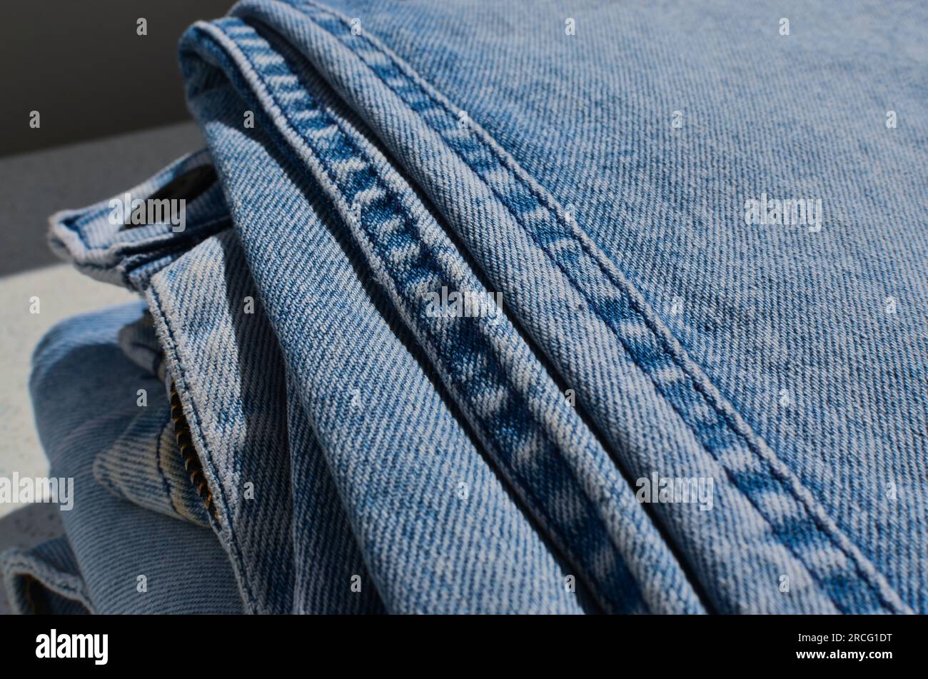 Dettaglio ravvicinato della cucitura di un paio di jeans, che mostra l'impeccabile finitura delle linee.000- ideale per progetti di moda e abbigliamento. Foto Stock