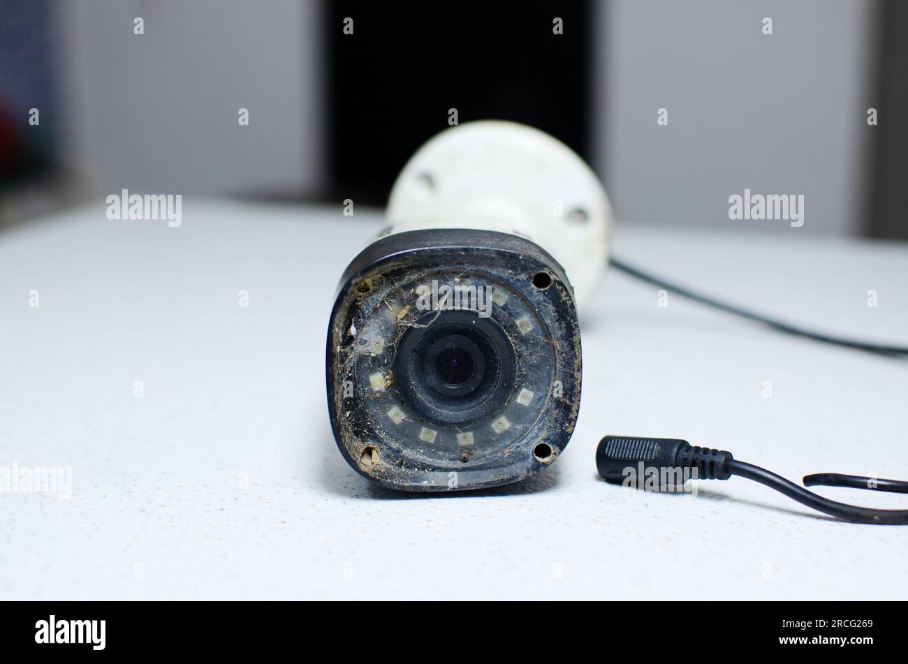 Immagine ravvicinata di una telecamera di sicurezza deteriorata, evidenziando l'importanza della manutenzione preventiva per evitare guasti al sistema di sorveglianza. Foto Stock