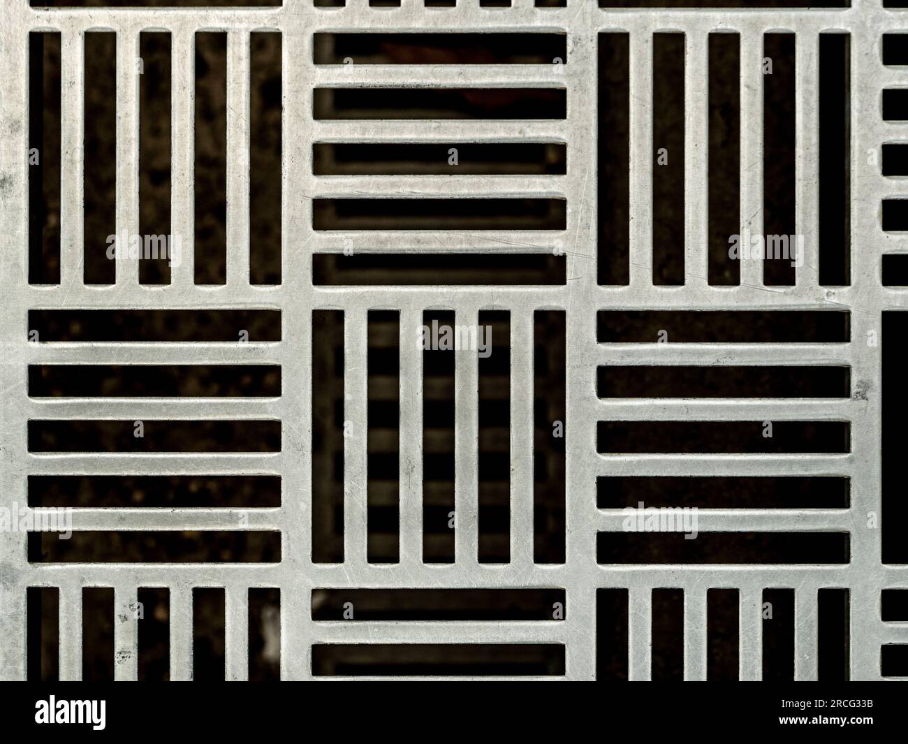 Primo piano di una griglia da pavimento decorativa in metallo contemporanea. Foto Stock