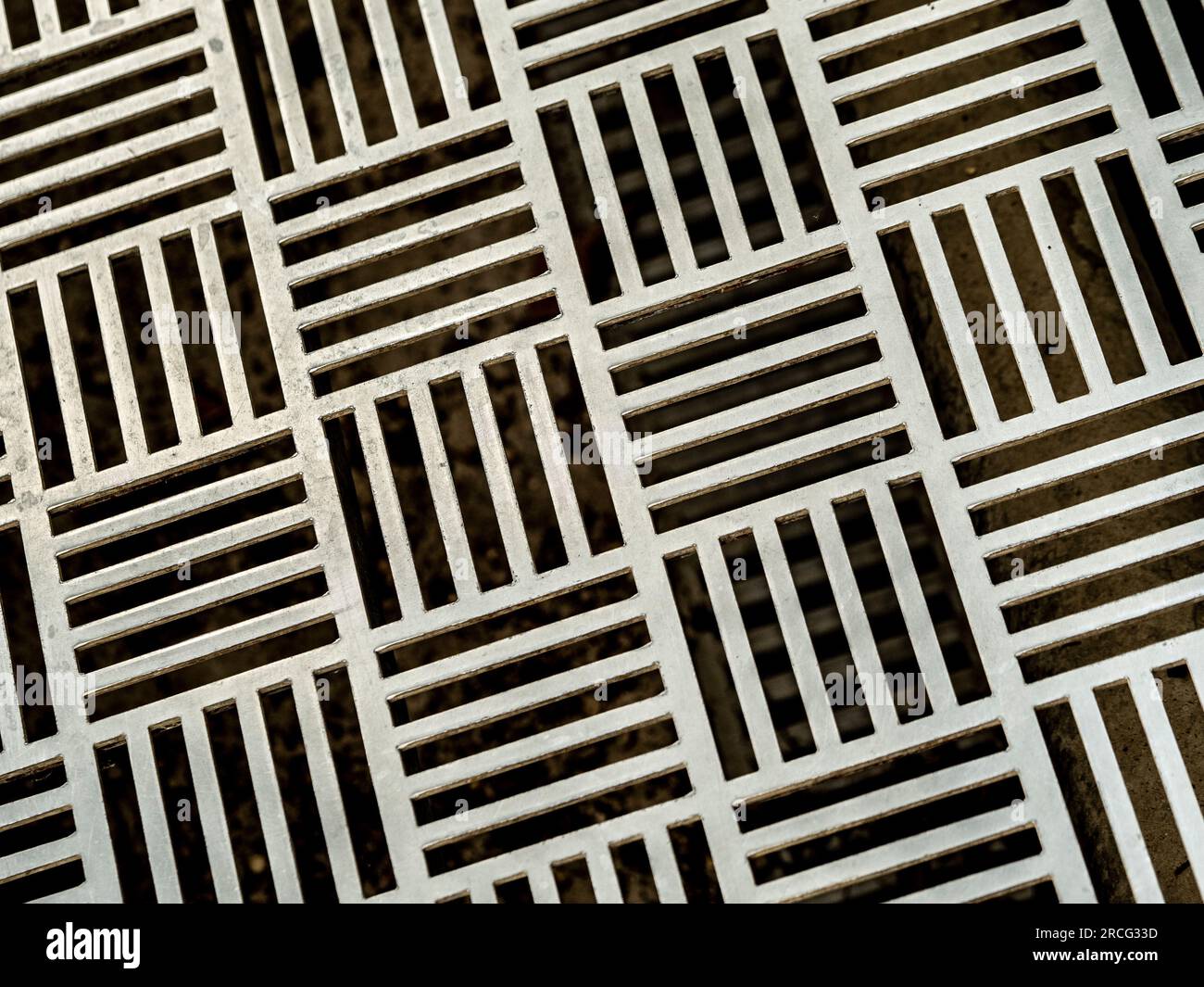 Primo piano di una griglia da pavimento decorativa in metallo contemporanea. Foto Stock