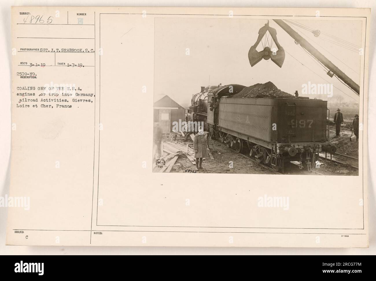 I soldati americani caricano uno dei loro motori in preparazione di un viaggio in Germania durante la prima guerra mondiale. Questa foto è stata scattata a Gievres, Loire et Cher, in Francia, dal fotografo SOT. J.T. Seabrook. L'immagine è numerata 48965 ed è stata catturata il 7 gennaio 1919. Sul retro sono riportate le note "Med 31-19 2509-19" e "Coal TAKEN: 1-7-19+" Foto Stock