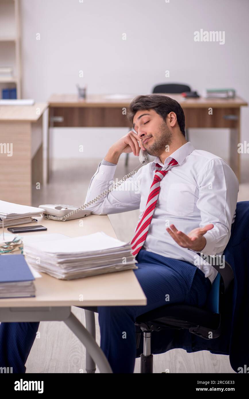 Giovane impiegato di sesso maschile seduto sul posto di lavoro Foto stock -  Alamy