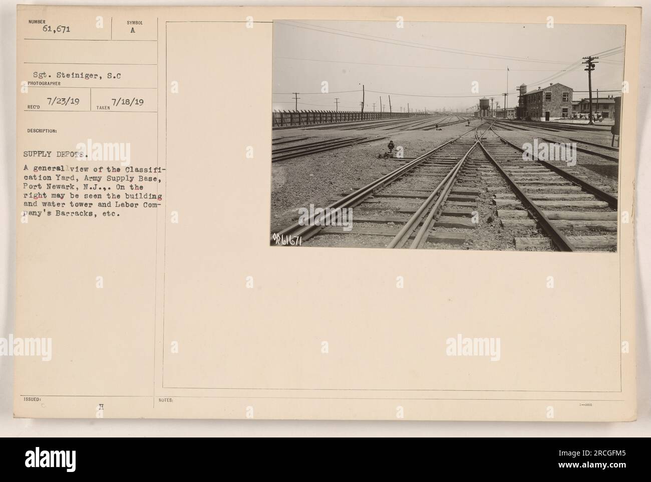 Una veduta del Classification Yard presso la base di rifornimento dell'esercito a Port Newark, New Jersey. Nella foto c'è un edificio, una torre dell'acqua e la caserma della compagnia del lavoro. Fotografato dal sergente Steiniger il 18 luglio 1919. Fa parte di una serie di documenti che documentano i depositi di rifornimento durante la prima guerra mondiale. Foto Stock