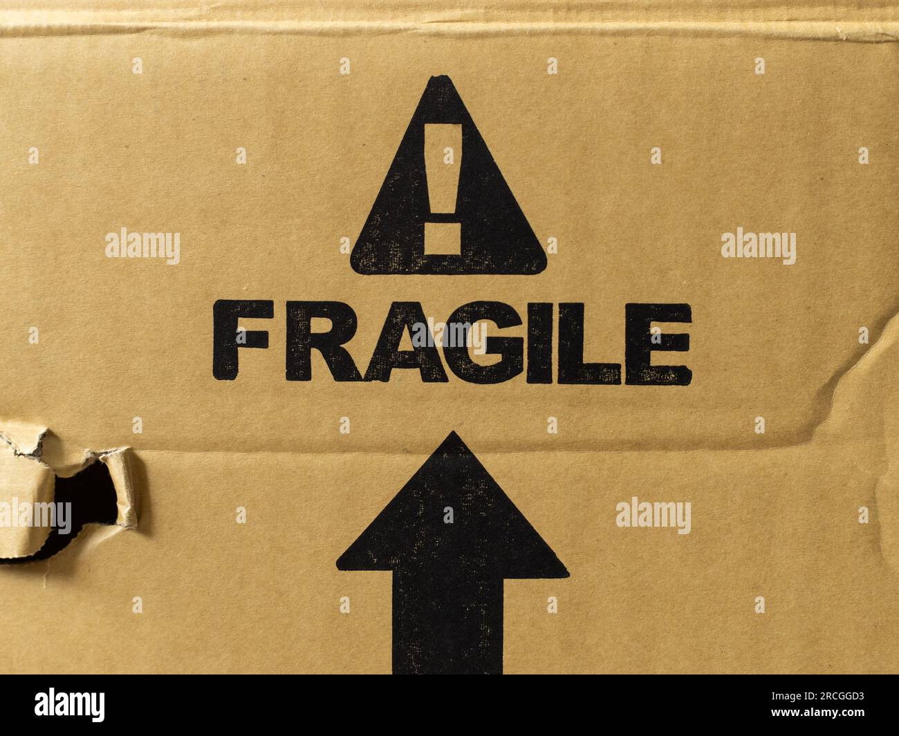 Etichetta fragile su una confezione. Spedizione del materiale di cartone con l'avviso che il prodotto all'interno può rompersi quando la scatola viene gettata in giro. Foto Stock