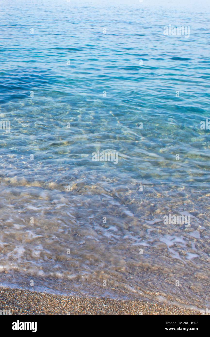 Splendida spiaggia sabbiosa e soffice onda blu dell'oceano. Riposati sulla spiaggia in un luogo pulito dal punto di vista ecologico. Foto Stock