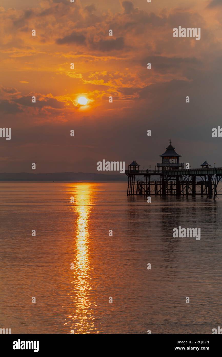 Molo di Clevedon al tramonto con una striscia di luce solare che attraversa il canale Foto Stock