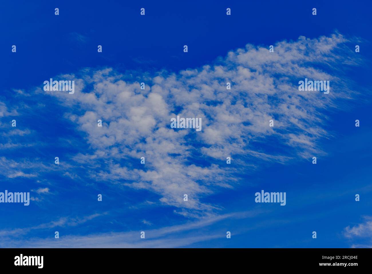 Wispy nuvole contro un cielo blu Foto Stock