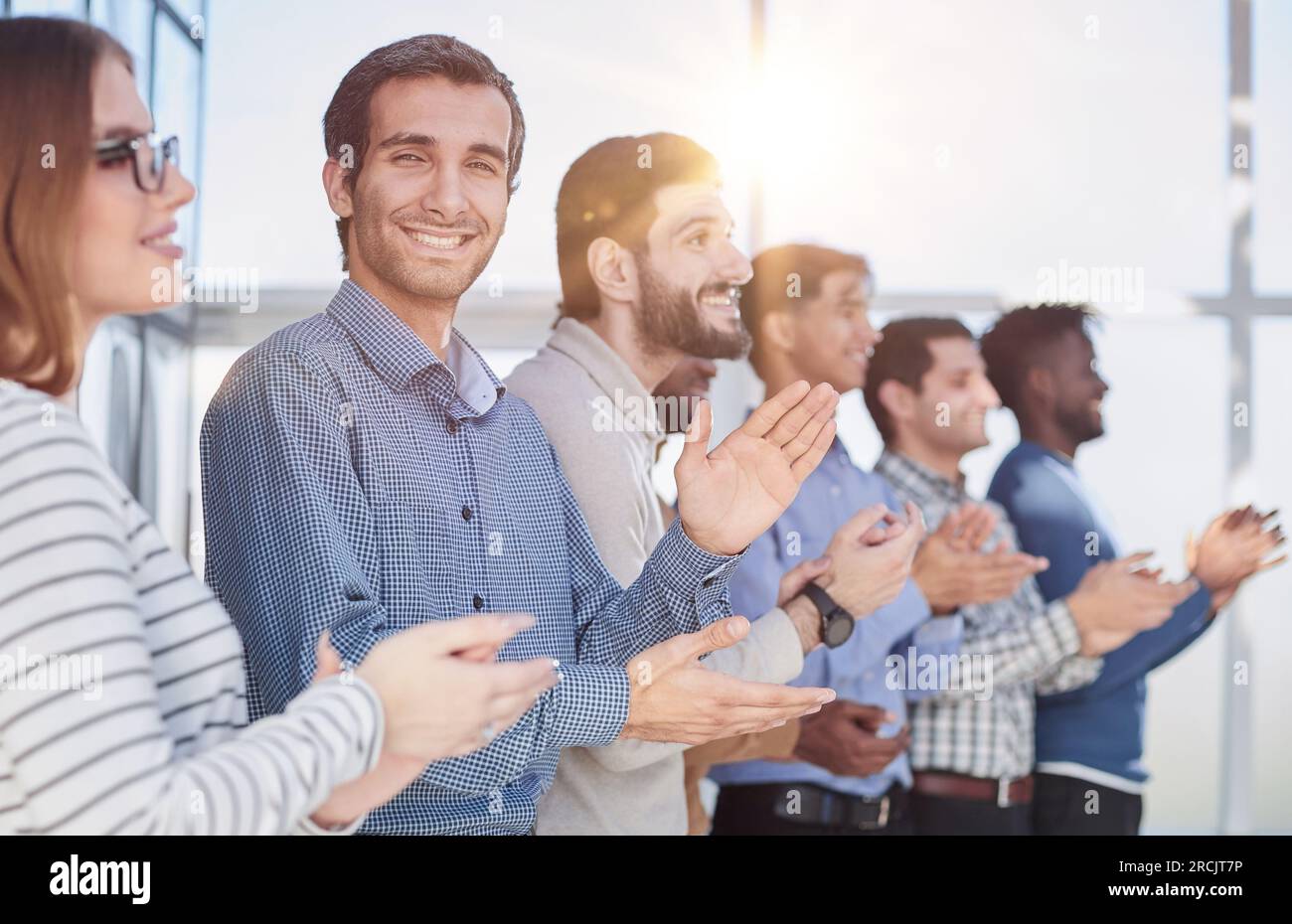Un team di lavoro felice applaudendo dopo una riunione di successo Foto Stock