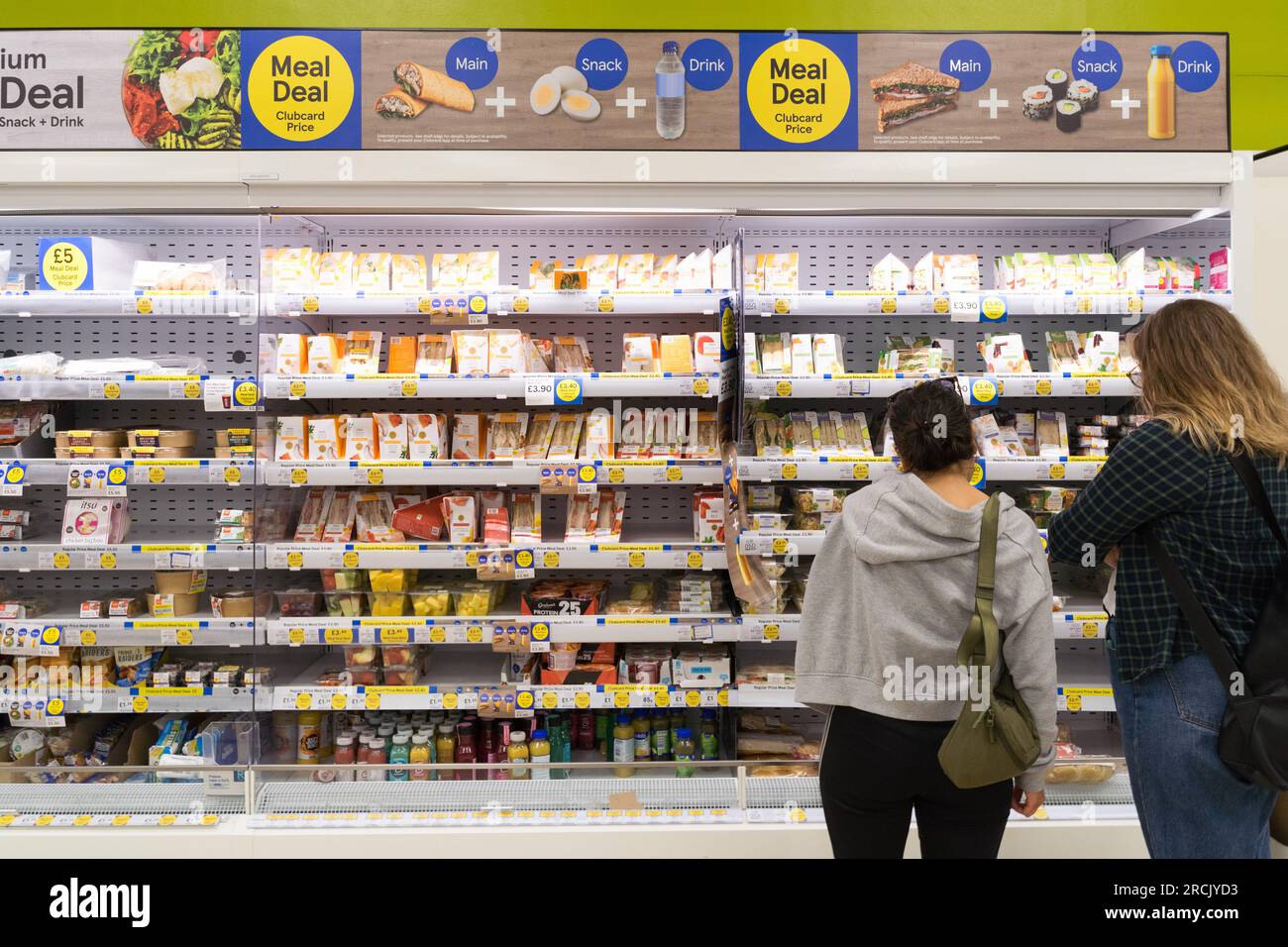 Gli acquirenti fanno una selezione di offerte pasto con prezzo clubcard al supermercato TESCO di Londra Regno Unito Foto Stock