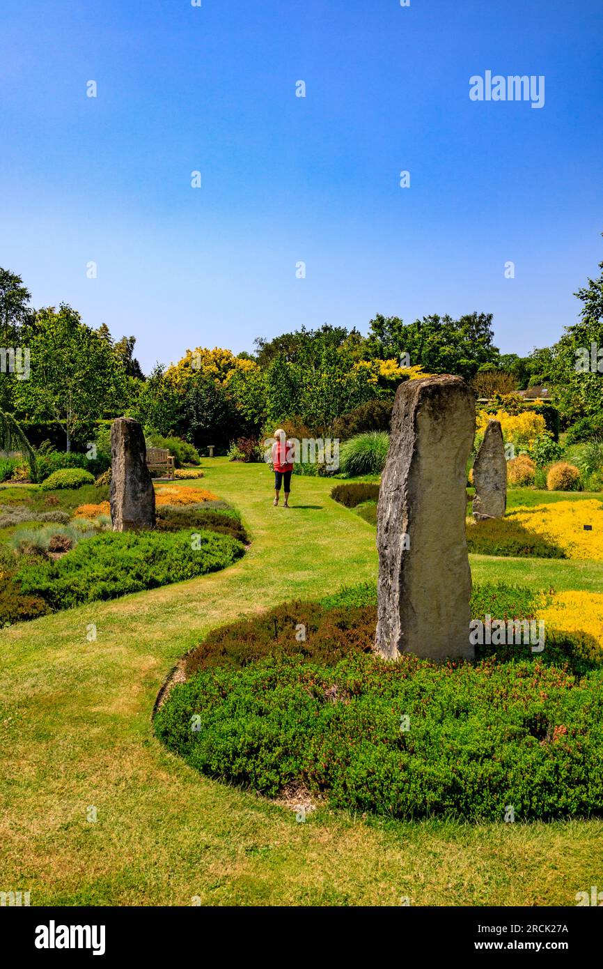 Una visitatrice che girovagava per i monoliti di pietra di Holme Henge Purbeck e le orme colorate presso gli Holme Gardens vicino a Wareham, Dorset, Inghilterra, Regno Unito Foto Stock