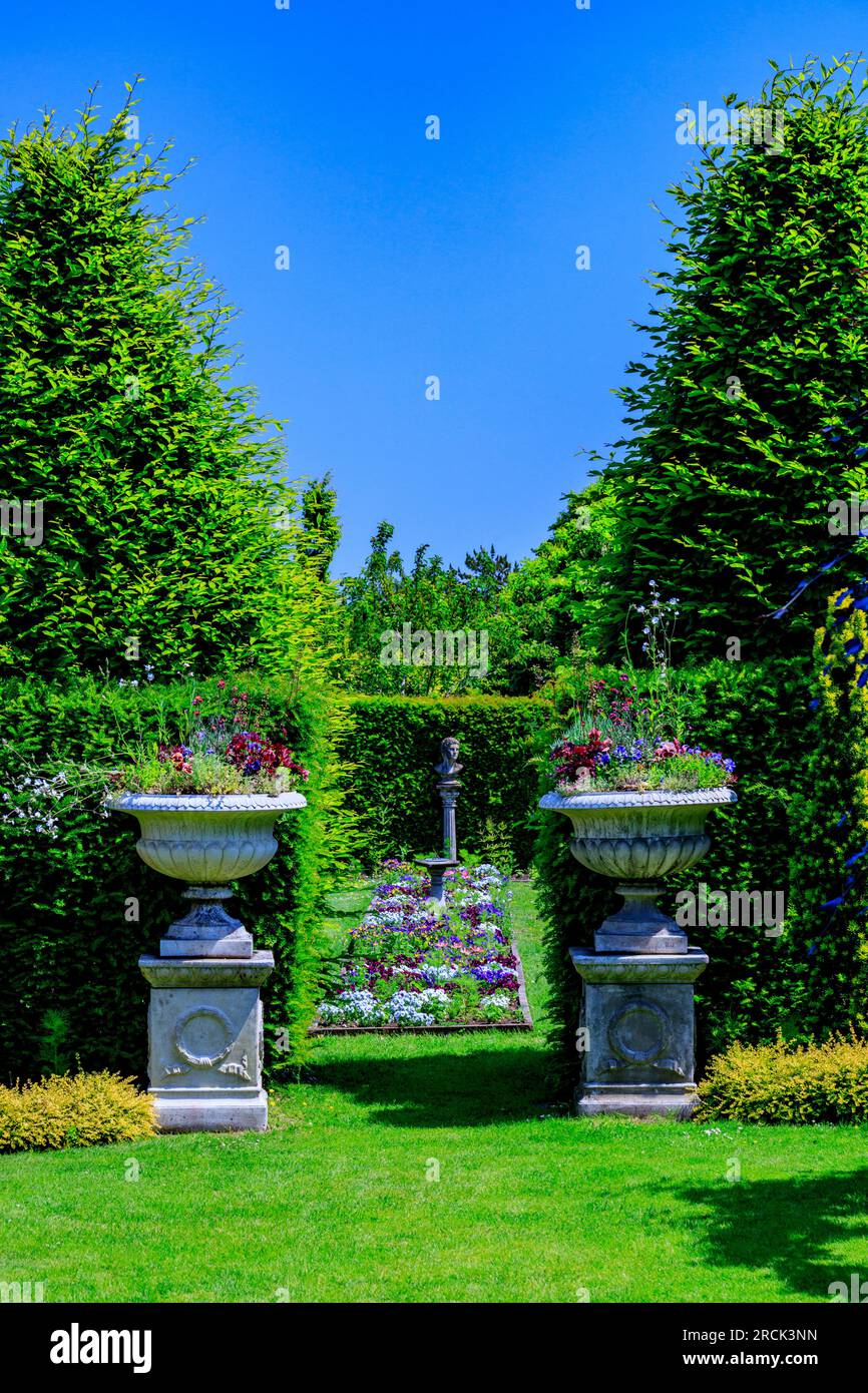 Le caratteristiche siepi alte e il colorato confine centrale del Canal Garden presso i giardini paesaggistici di Holme Gardens vicino a Wareham, Dorset, Inghilterra, Regno Unito Foto Stock