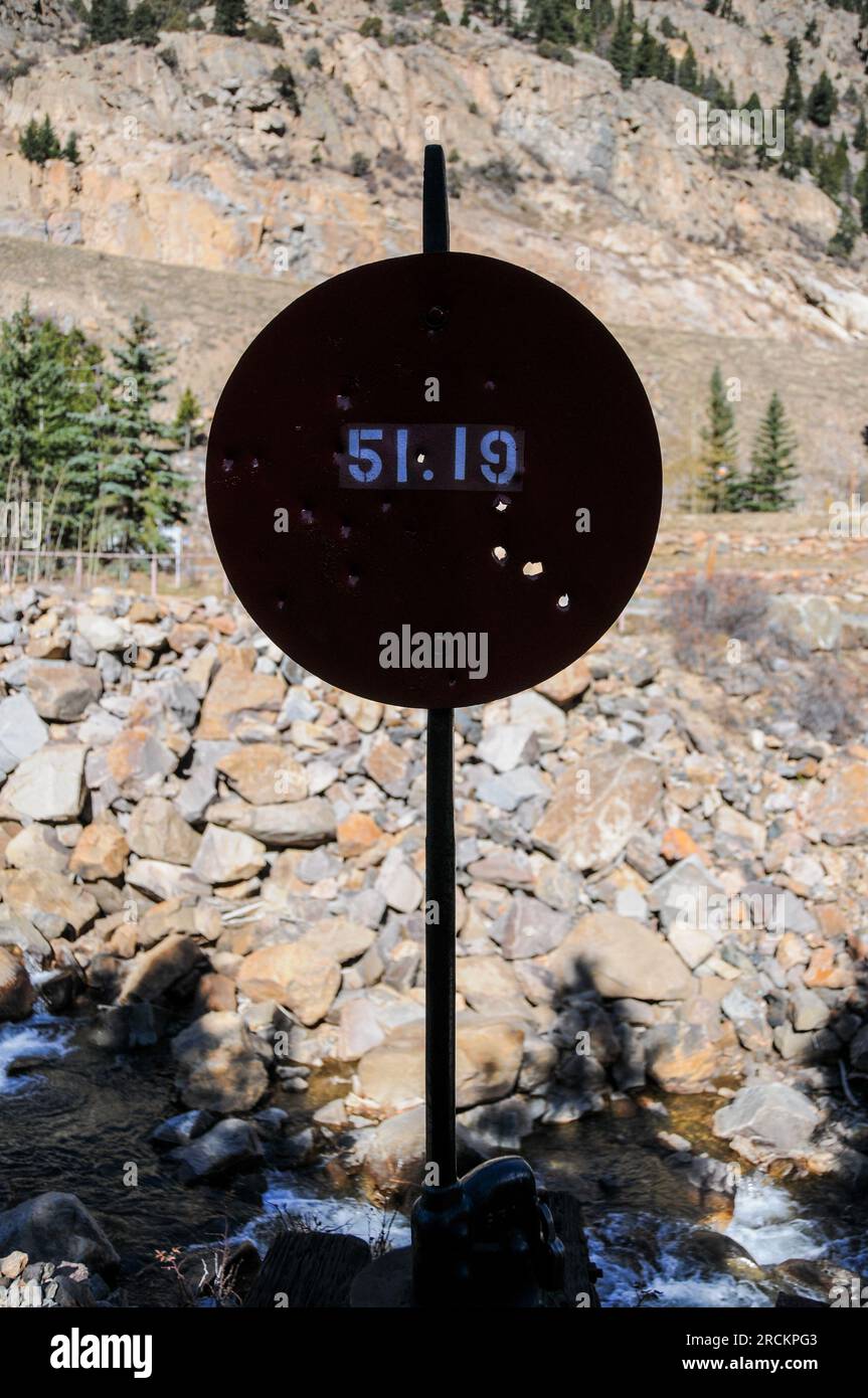 Bersaglio di colpi d'arma da fuoco e fori di proiettile sul cartello rosso della ferrovia in Colorado, Stati Uniti Foto Stock
