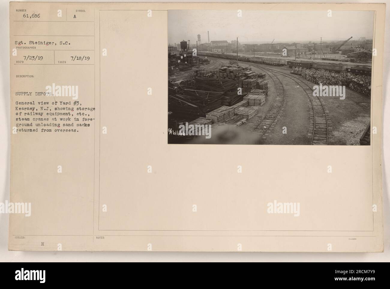 Questa fotografia mostra Yard #3 a Kearney, N.J., che servì come deposito di rifornimenti durante la prima guerra mondiale Al momento della foto, il 23 luglio 1919, si possono vedere gru a vapore che scaricano sacchi di sabbia che sono stati restituiti dall'estero. Il deposito contiene attrezzature ferroviarie e altre forniture. La foto è stata scattata dal sergente Steiniger e il numero di riferimento è 61686. Foto Stock