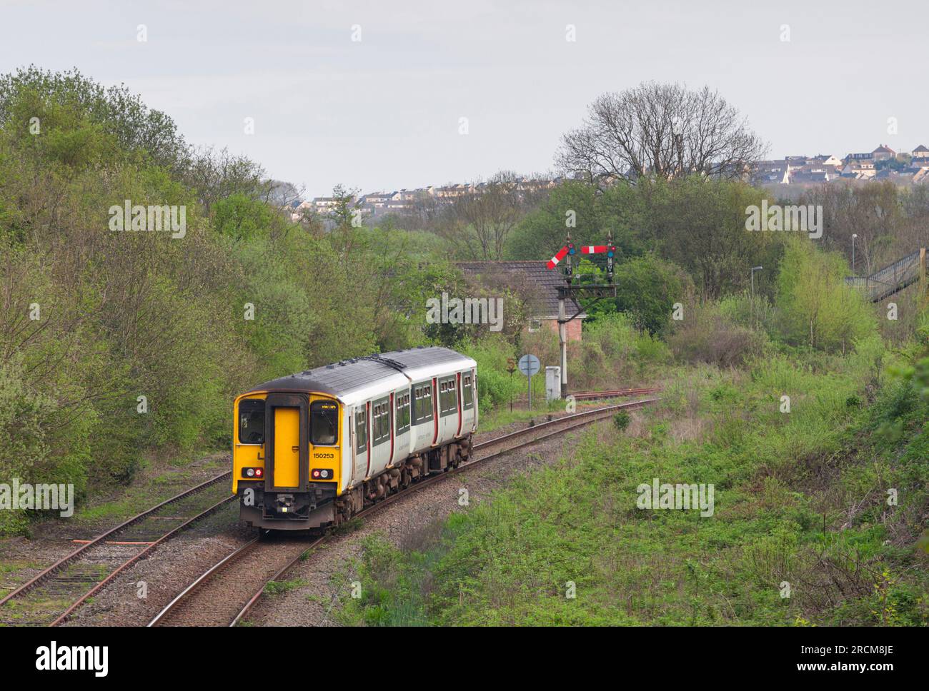 Trasporto per il Galles classe 150 DMU train150253 che passa il segnale della staffa meccanica del quadrante inferiore a Tondu, Galles meridionale Foto Stock