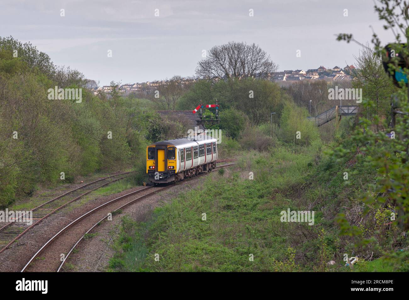 Trasporto per il Galles classe 150 DMU train150253 che passa il segnale della staffa meccanica del quadrante inferiore a Tondu, Galles meridionale Foto Stock