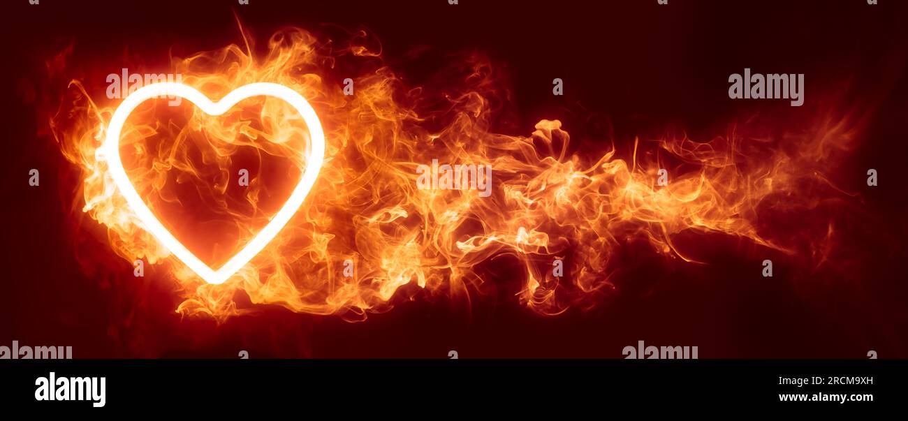 Cuore splendente in un inferno di carta da parati con fiamme rosse o sullo sfondo di San Valentino. Simboleggia la passione, la lussuria o il desiderio. Foto Stock