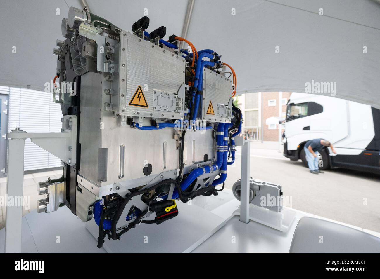Stoccarda, Germania. 12 luglio 2023. Un sistema di trasmissione a celle a combustibile per la generazione di elettricità dall'idrogeno nei veicoli è posizionato su un piedistallo di fronte a un camion alimentato a idrogeno. Il cosiddetto modulo di alimentazione delle celle a combustibile (FCPM) viene utilizzato principalmente nei veicoli commerciali e nelle applicazioni a lunga distanza. L'FCPM è costituito da una o due pile di celle a combustibile e da altri componenti necessari per azionare le pile. Crediti: Marijan Murat/dpa/Alamy Live News Foto Stock