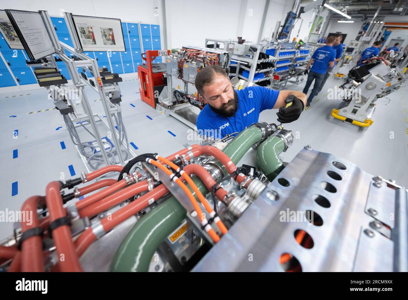 Stoccarda, Germania. 12 luglio 2023. I dipendenti della Robert Bosch GmbH assemblano sistemi di trasmissione delle celle a combustibile in produzione per la generazione di elettricità dall'idrogeno nei veicoli. Il cosiddetto modulo di alimentazione delle celle a combustibile (FCPM) viene utilizzato principalmente nei veicoli commerciali e nelle applicazioni a lunga distanza. L'FCPM è costituito da una o due pile di celle a combustibile e da altri componenti necessari per azionare le pile. Crediti: Marijan Murat/dpa/Alamy Live News Foto Stock