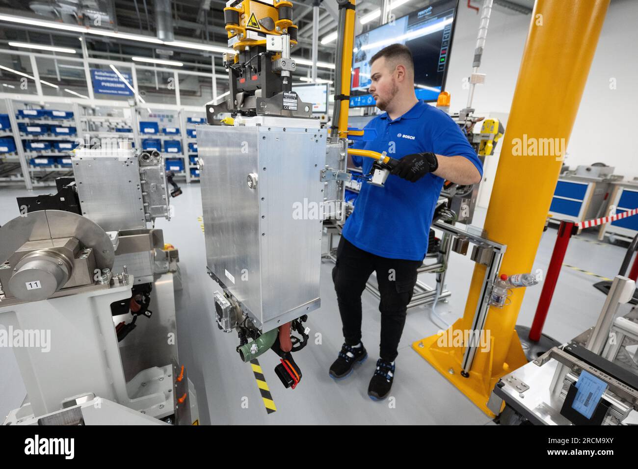 Stoccarda, Germania. 12 luglio 2023. Un dipendente della Robert Bosch GmbH collega una pila di celle a combustibile a un sistema di azionamento delle celle a combustibile per generare elettricità dall'idrogeno nei veicoli durante la produzione. Il cosiddetto modulo di alimentazione delle celle a combustibile (FCPM) viene utilizzato principalmente nei veicoli commerciali e nelle applicazioni a lunga distanza. L'FCPM è costituito da una o due pile di celle a combustibile e da altri componenti necessari per azionare le pile. Crediti: Marijan Murat/dpa/Alamy Live News Foto Stock