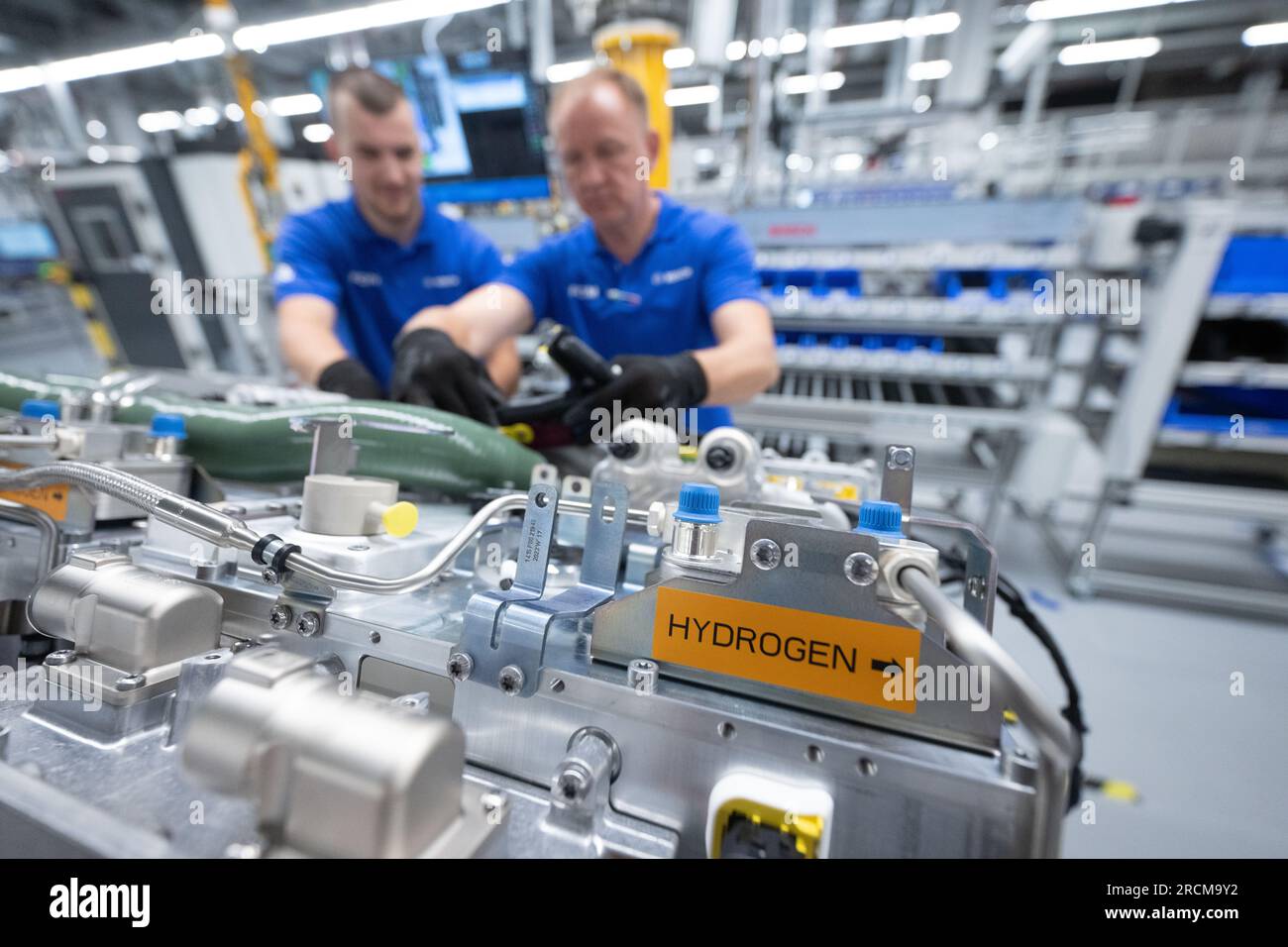 Stoccarda, Germania. 12 luglio 2023. I dipendenti della Robert Bosch GmbH assemblano sistemi di trasmissione delle celle a combustibile in produzione per la generazione di elettricità dall'idrogeno nei veicoli. Il cosiddetto modulo di alimentazione delle celle a combustibile (FCPM) viene utilizzato principalmente nei veicoli commerciali e nelle applicazioni a lunga distanza. L'FCPM è costituito da una o due pile di celle a combustibile e da altri componenti necessari per azionare le pile. Crediti: Marijan Murat/dpa/Alamy Live News Foto Stock