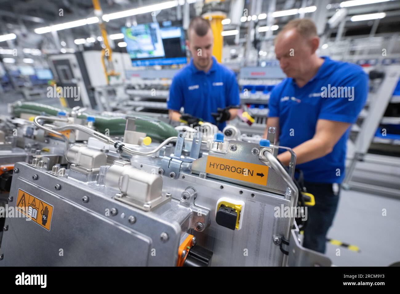 Stoccarda, Germania. 12 luglio 2023. I dipendenti della Robert Bosch GmbH assemblano sistemi di trasmissione delle celle a combustibile in produzione per la generazione di elettricità dall'idrogeno nei veicoli. Il cosiddetto modulo di alimentazione delle celle a combustibile (FCPM) viene utilizzato principalmente nei veicoli commerciali e nelle applicazioni a lunga distanza. L'FCPM è costituito da una o due pile di celle a combustibile e da altri componenti necessari per azionare le pile. Crediti: Marijan Murat/dpa/Alamy Live News Foto Stock