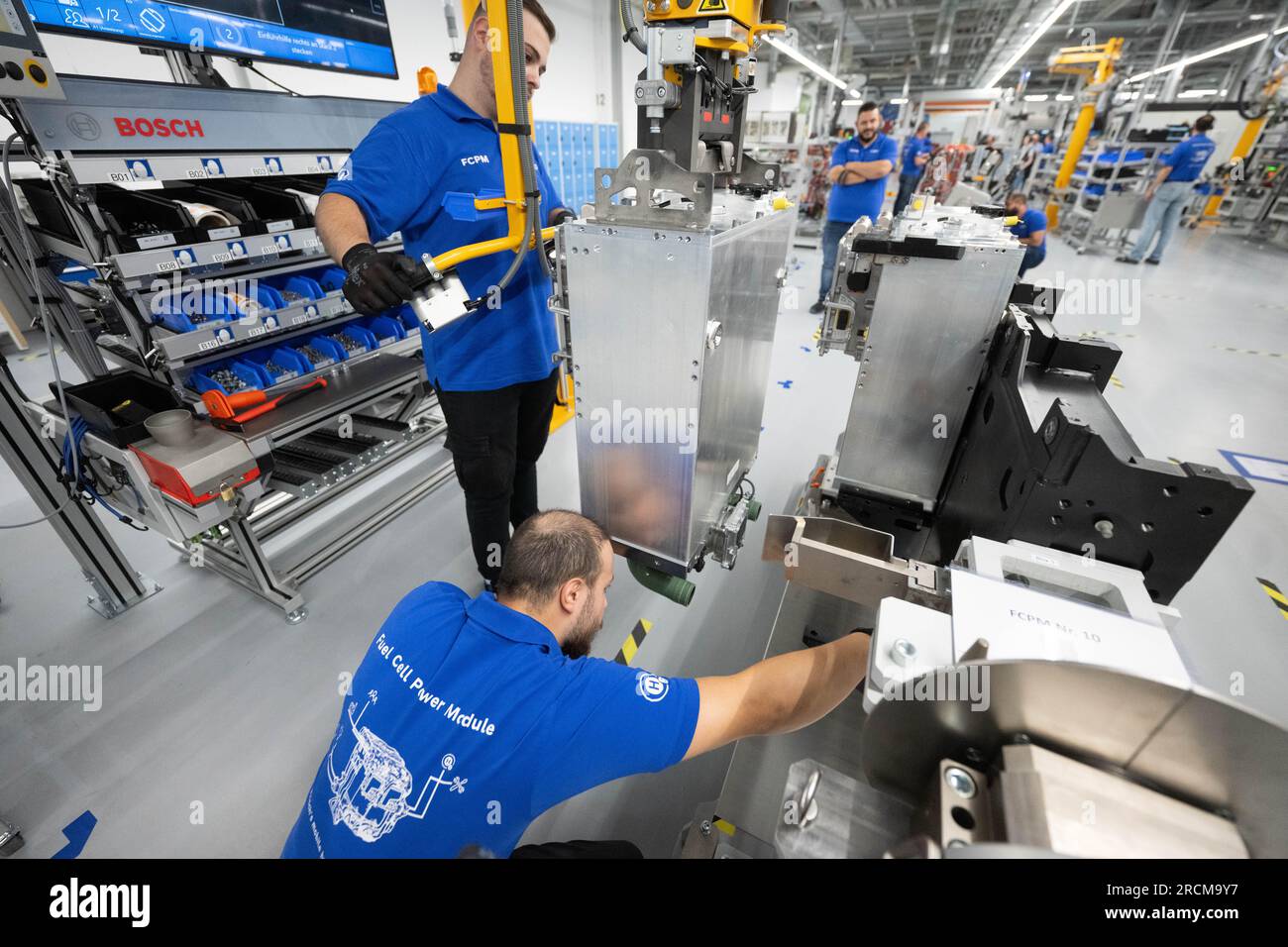 Stoccarda, Germania. 12 luglio 2023. I dipendenti della Robert Bosch GmbH collegano una pila di celle a combustibile a un sistema di comando celle a combustibile per generare elettricità dall'idrogeno nei veicoli durante la produzione. Il cosiddetto modulo di alimentazione delle celle a combustibile (FCPM) viene utilizzato principalmente nei veicoli commerciali e nelle applicazioni a lunga distanza. L'FCPM è costituito da una o due pile di celle a combustibile e da altri componenti necessari per azionare le pile. Crediti: Marijan Murat/dpa/Alamy Live News Foto Stock